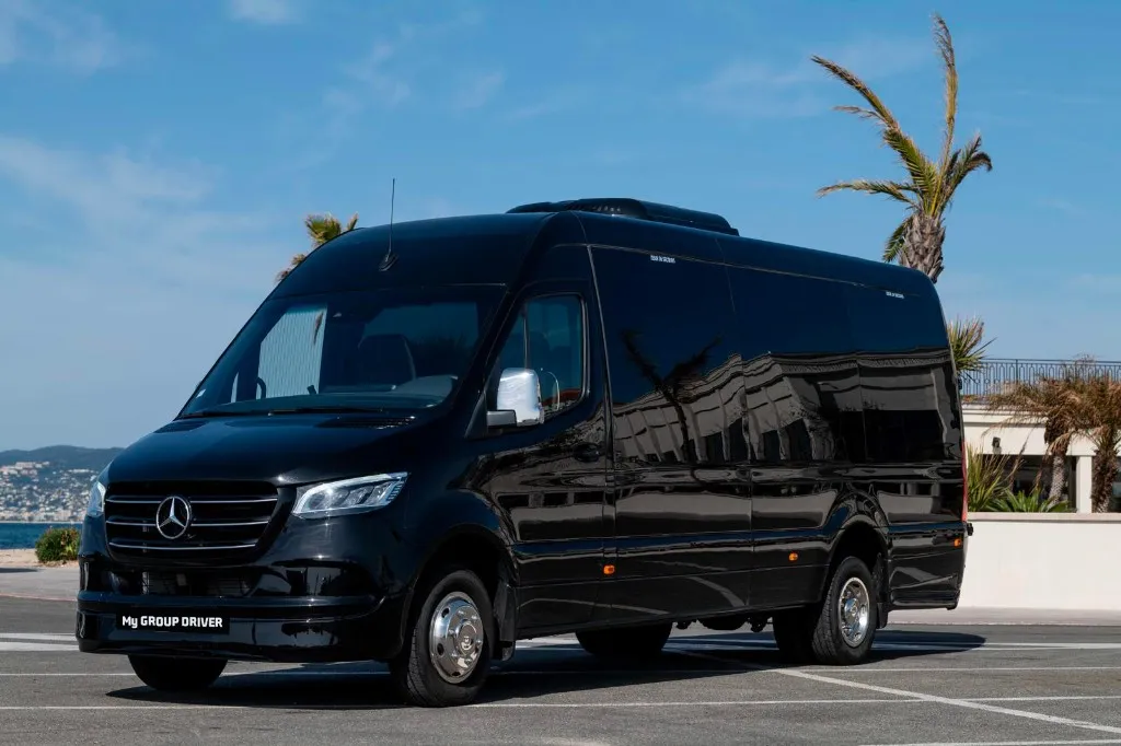 Minibus hire Nice: black Mercedes Sprinter parked by the sea with palm trees