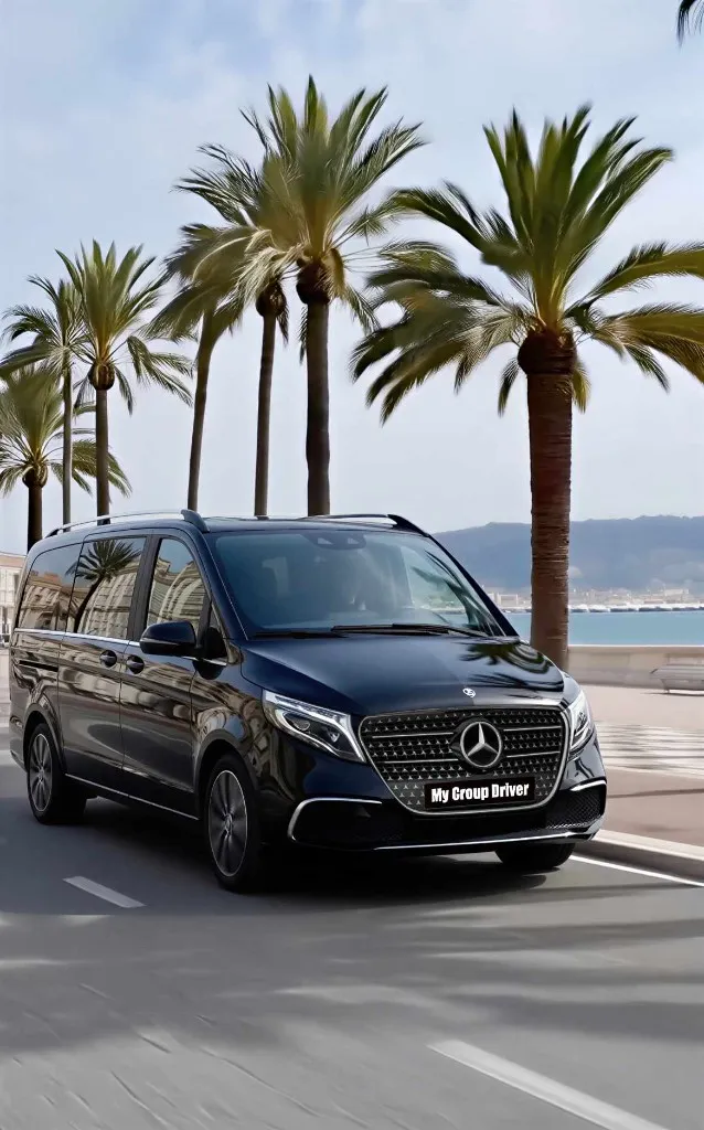 Private transfer French Riviera: black Mercedes V-Class on the Promenade des Anglais with palm trees and the sea