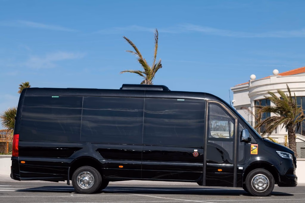 Transfert aéroport Saint-Tropez : minibus Mercedes Sprinter noir garé en bord de mer sous les palmiers