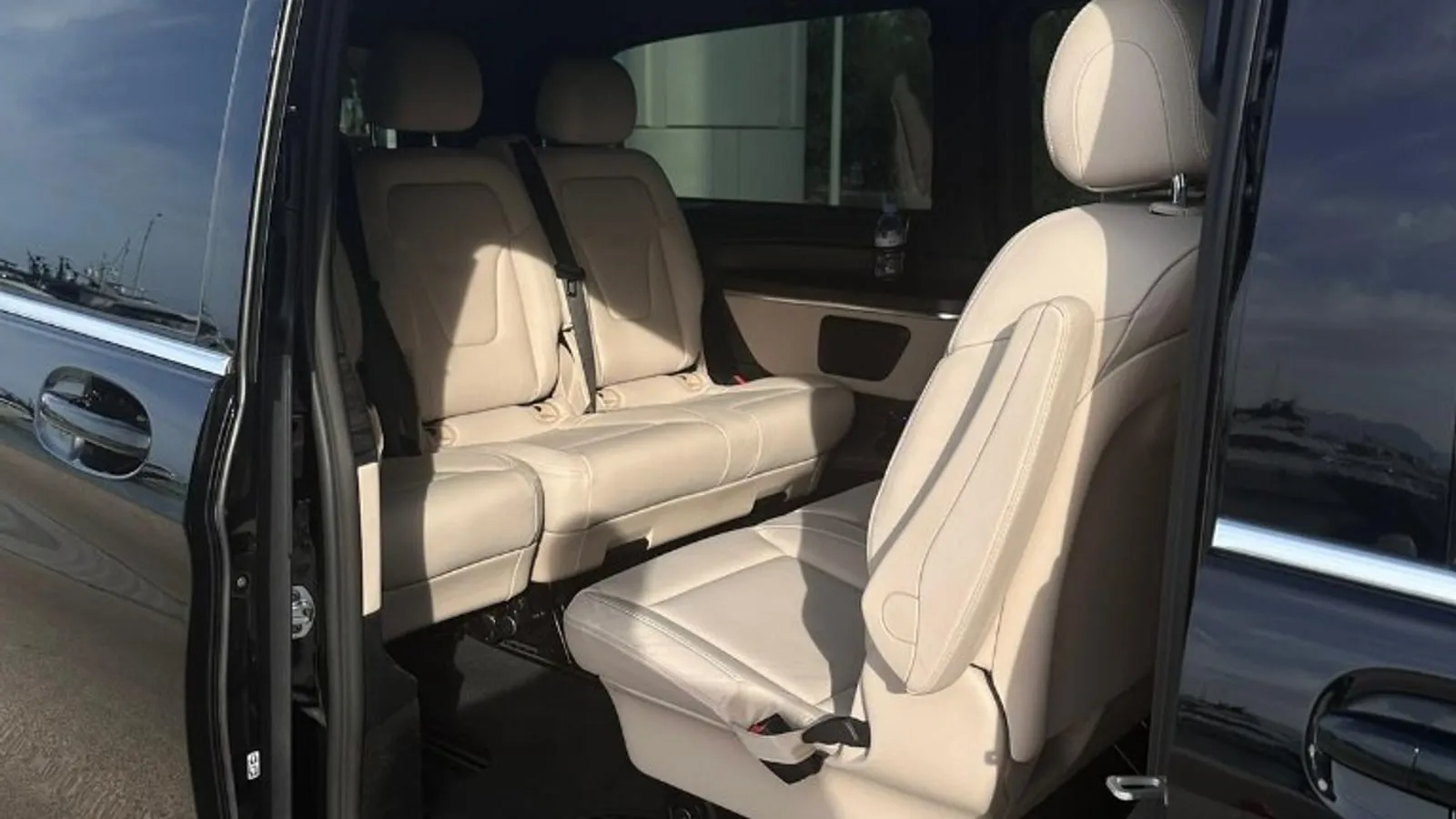 Chauffeur à disposition Côte d'Azur : sièges cuir crème à l'intérieur d'une Mercedes Classe V noire, porte coulissante ouverte